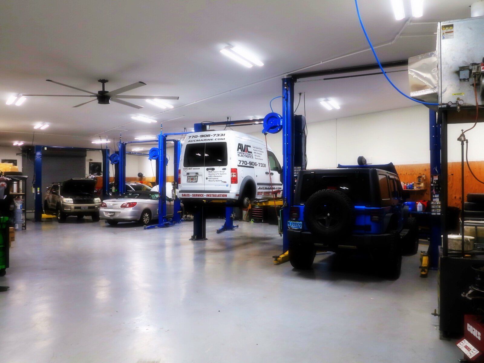 a white van is sitting on a lift in a garage