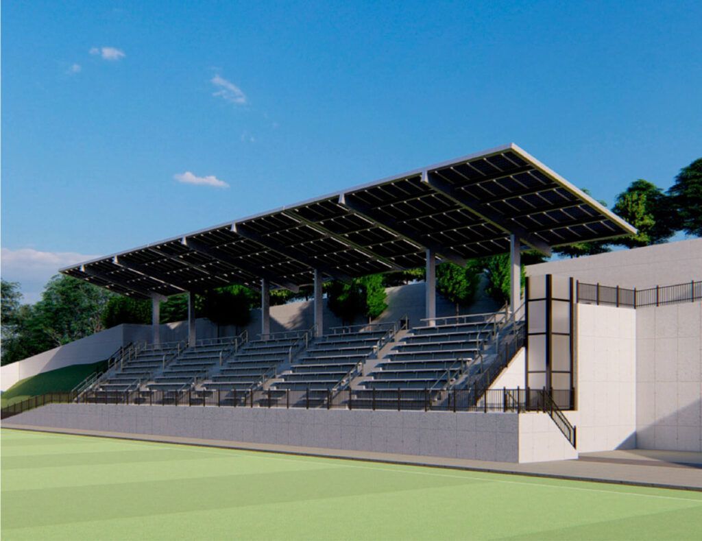 Empty covered stadium bleachers with a solar-panel roof on a sunny day