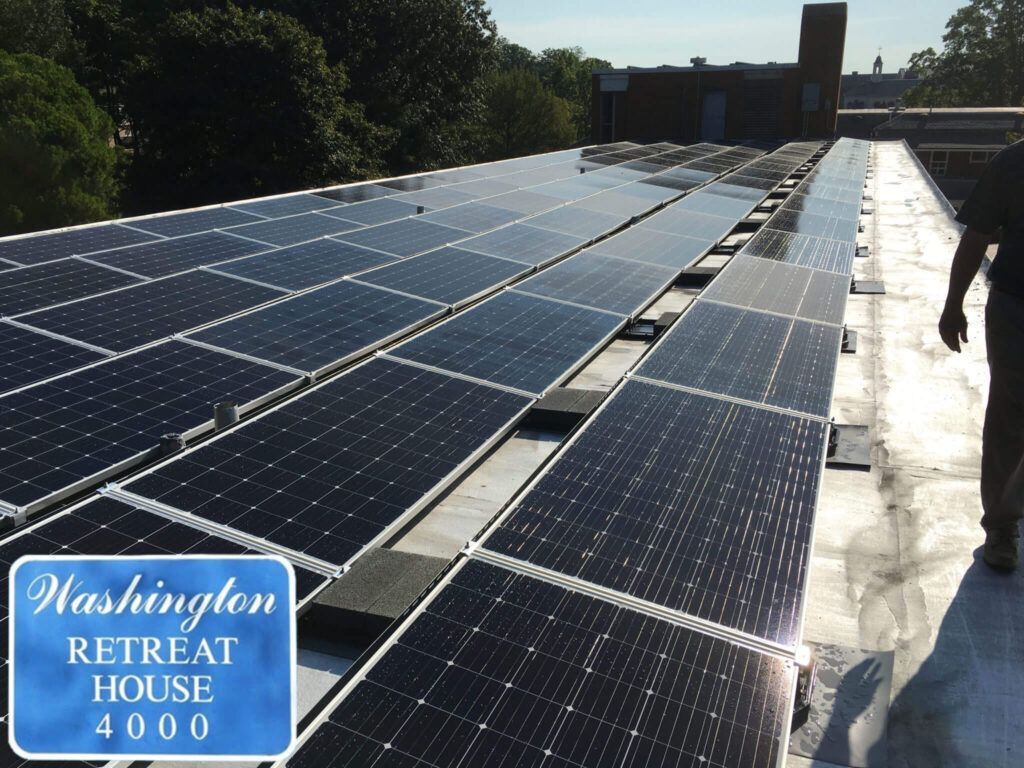 Rooftop solar panels at the White House, with a Washington Retreat House sign in the corner.