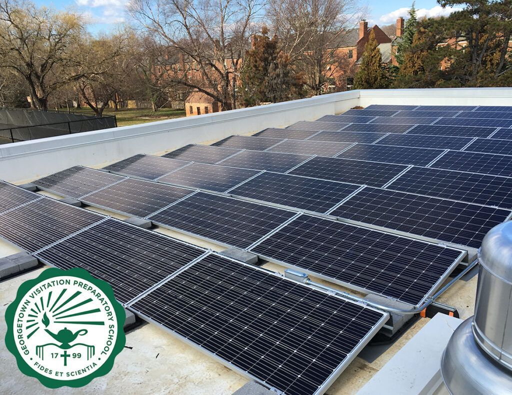 Solar panels covering a rooftop with trees and buildings in the background