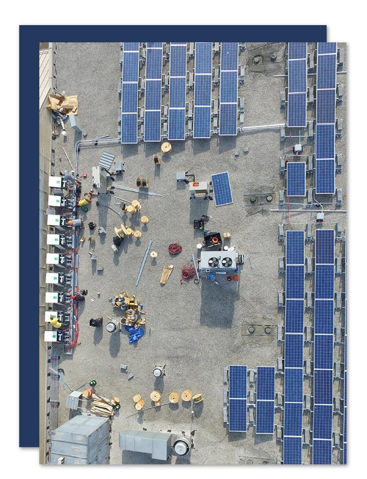Aerial view of workers and solar panel arrays on a construction site