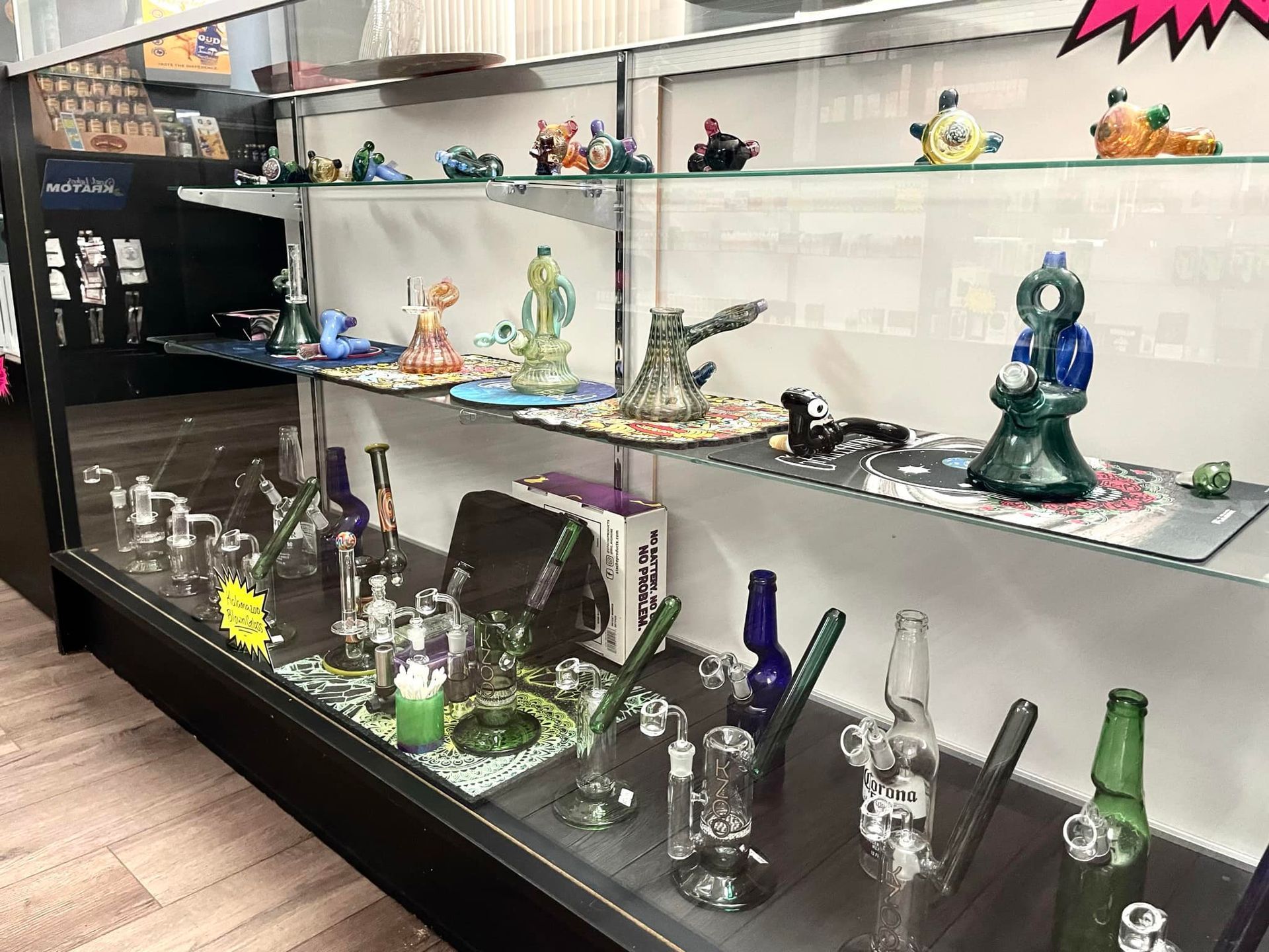A glass display case filled with a variety of glass pipes and bongs.
