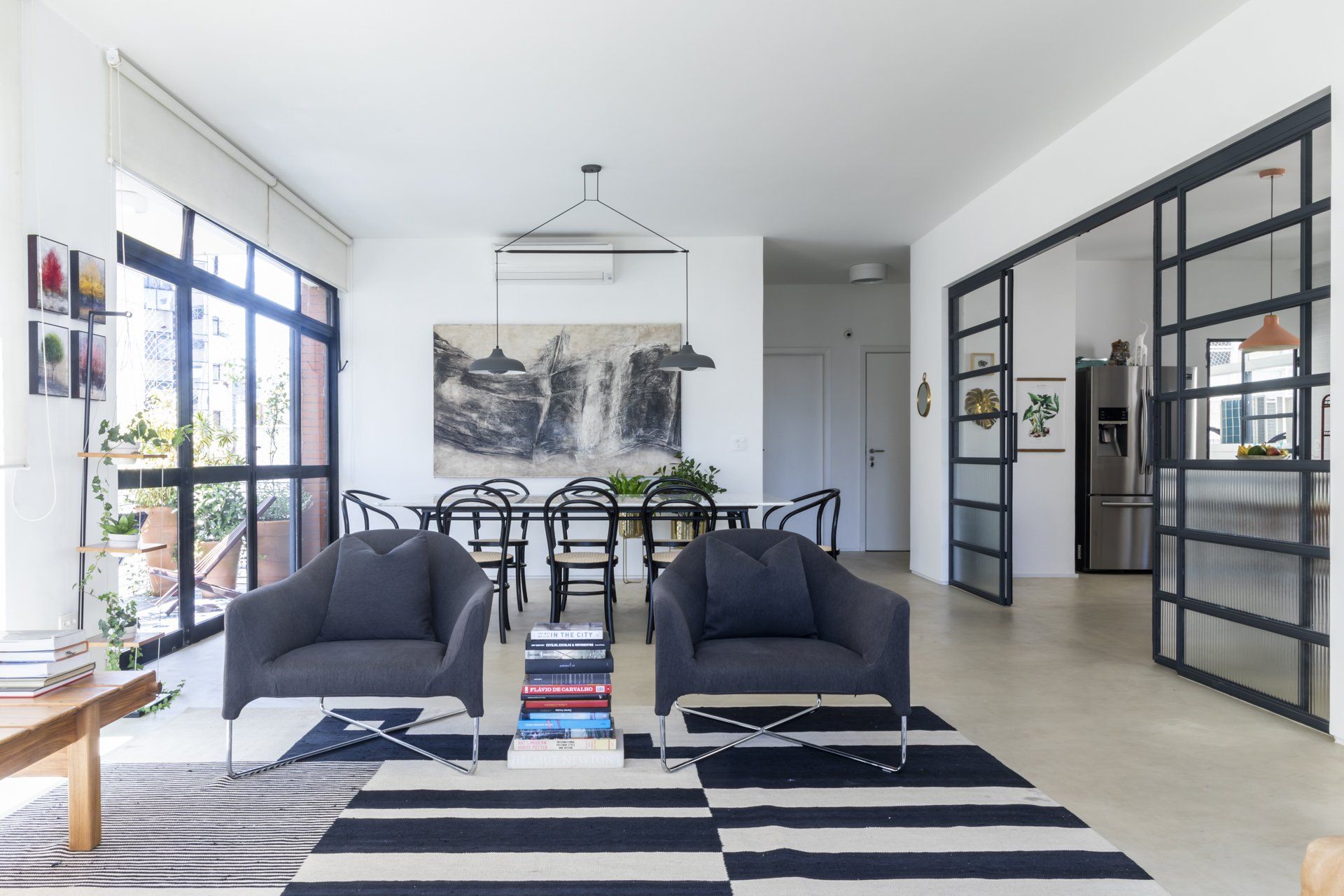 Uma sala com duas cadeiras pretas e um tapete preto e branco.