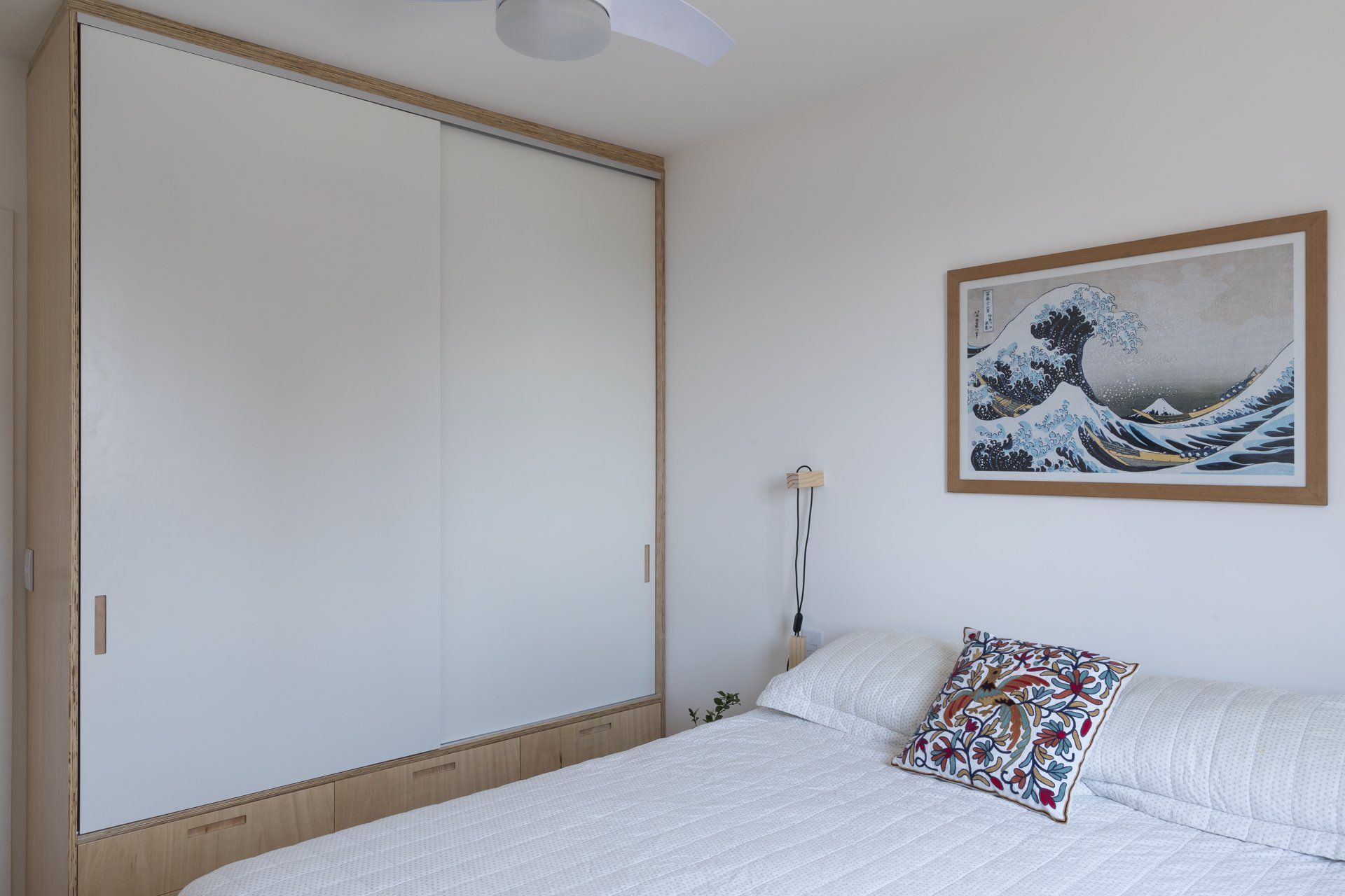 Um quarto com uma grande pintura na parede acima da cama