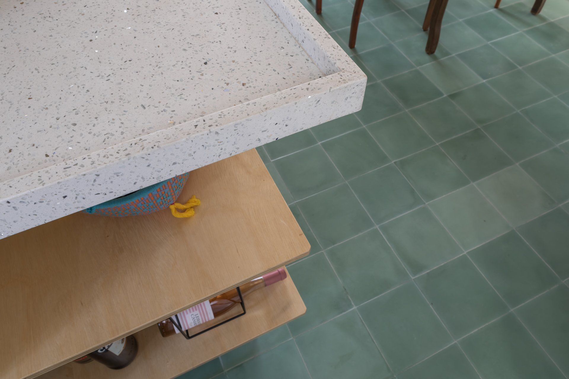 Uma cozinha com piso de cerâmica verde e bancada branca.