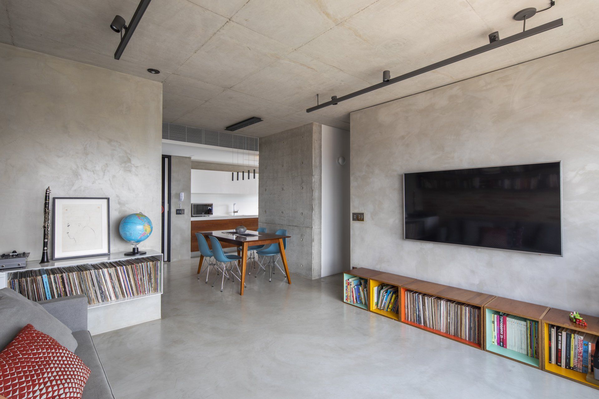 Uma sala de estar com mesa, cadeiras e TV de tela plana.