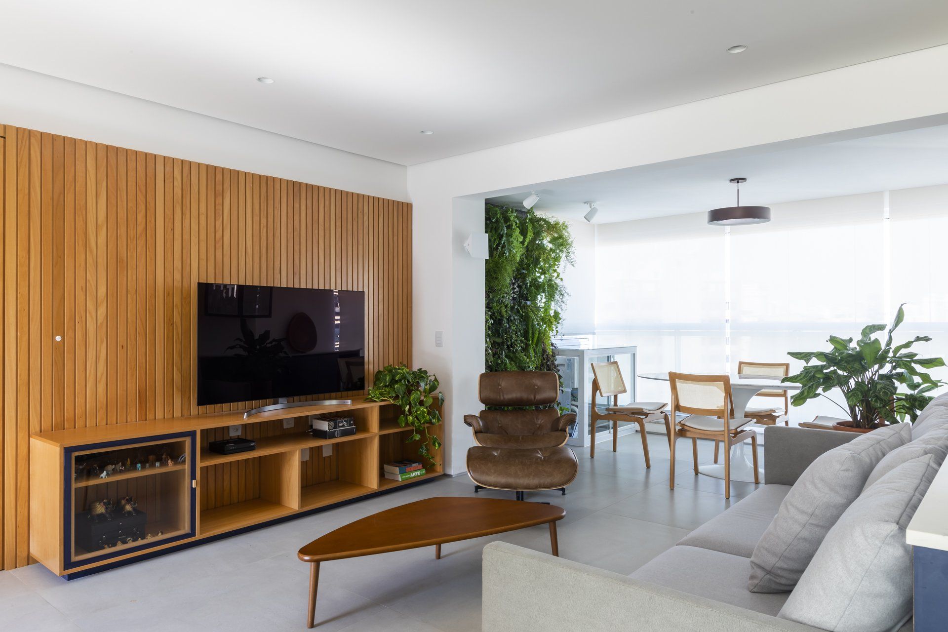 Uma sala de estar com sofá, mesa e televisão.