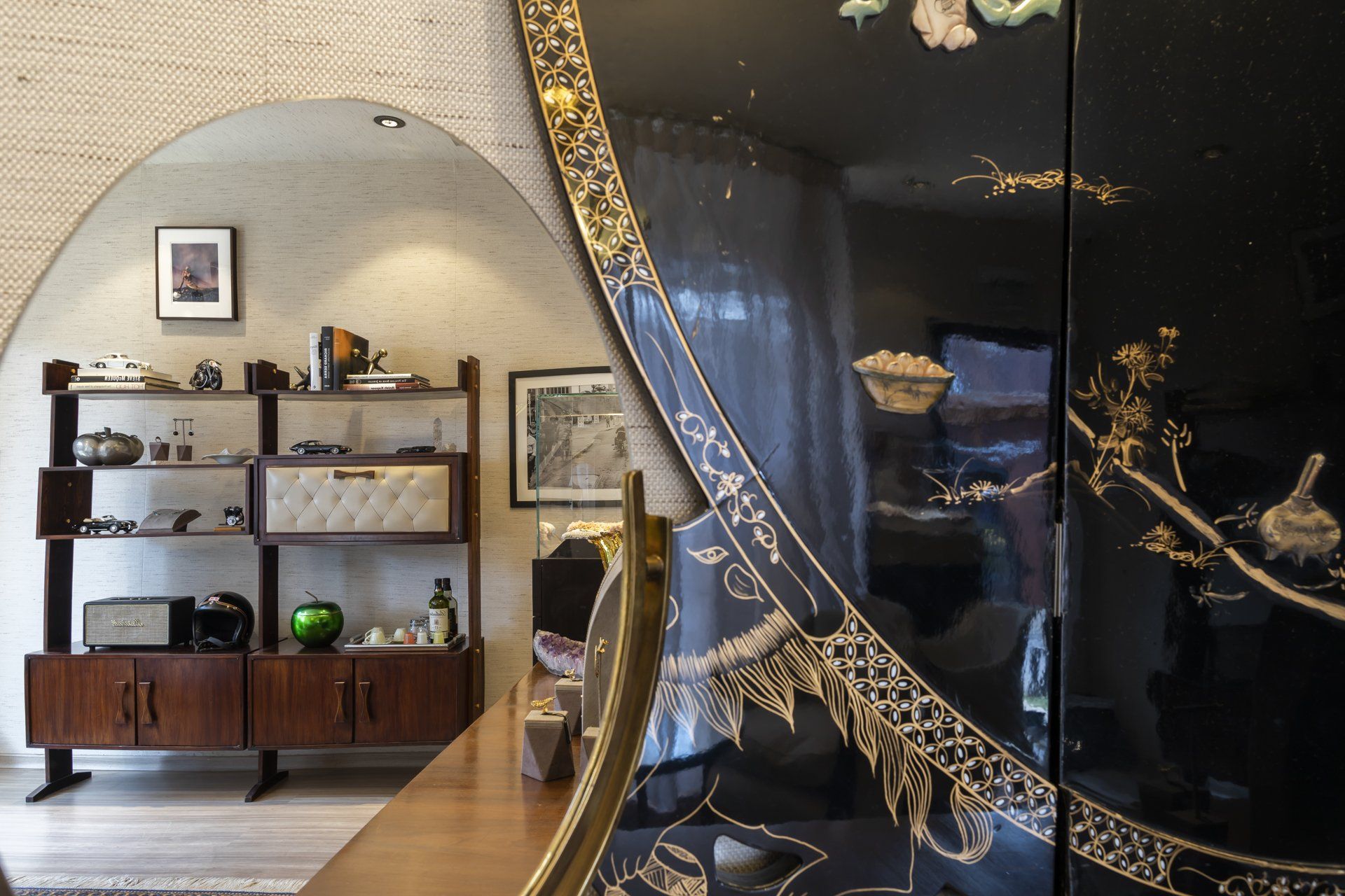 Uma sala de estar com um grande espelho e um armário preto