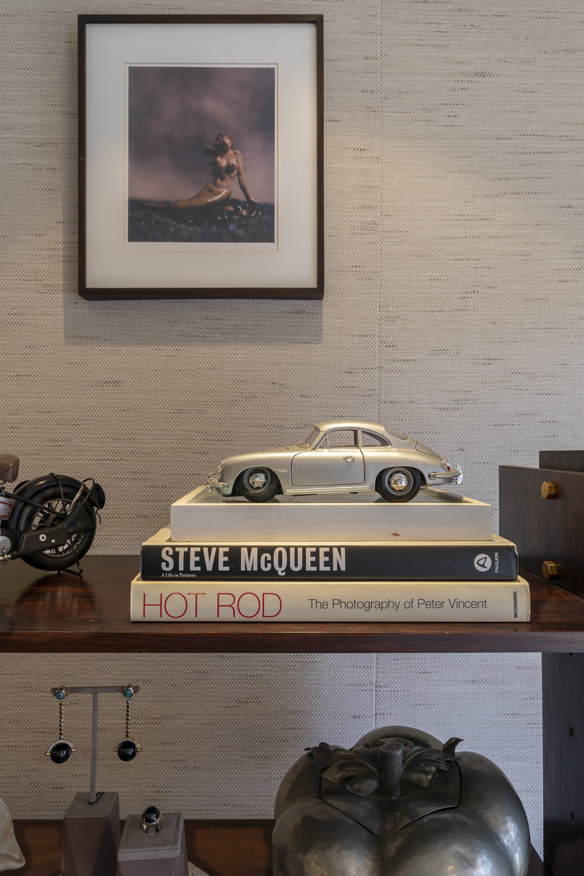Uma mesa com uma pilha de livros e a foto de um carro em cima dela.