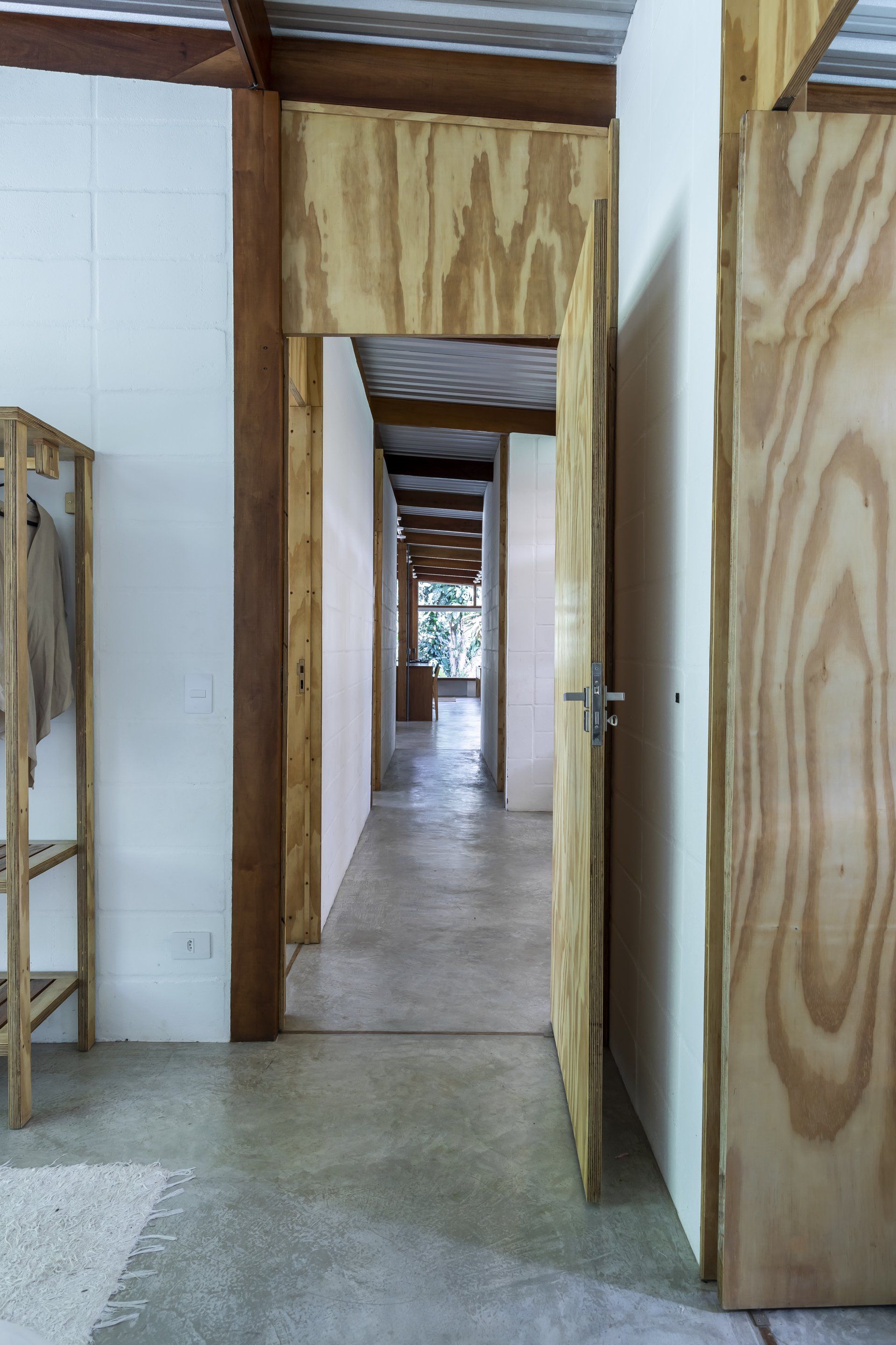 Um corredor com portas de madeira e piso de concreto