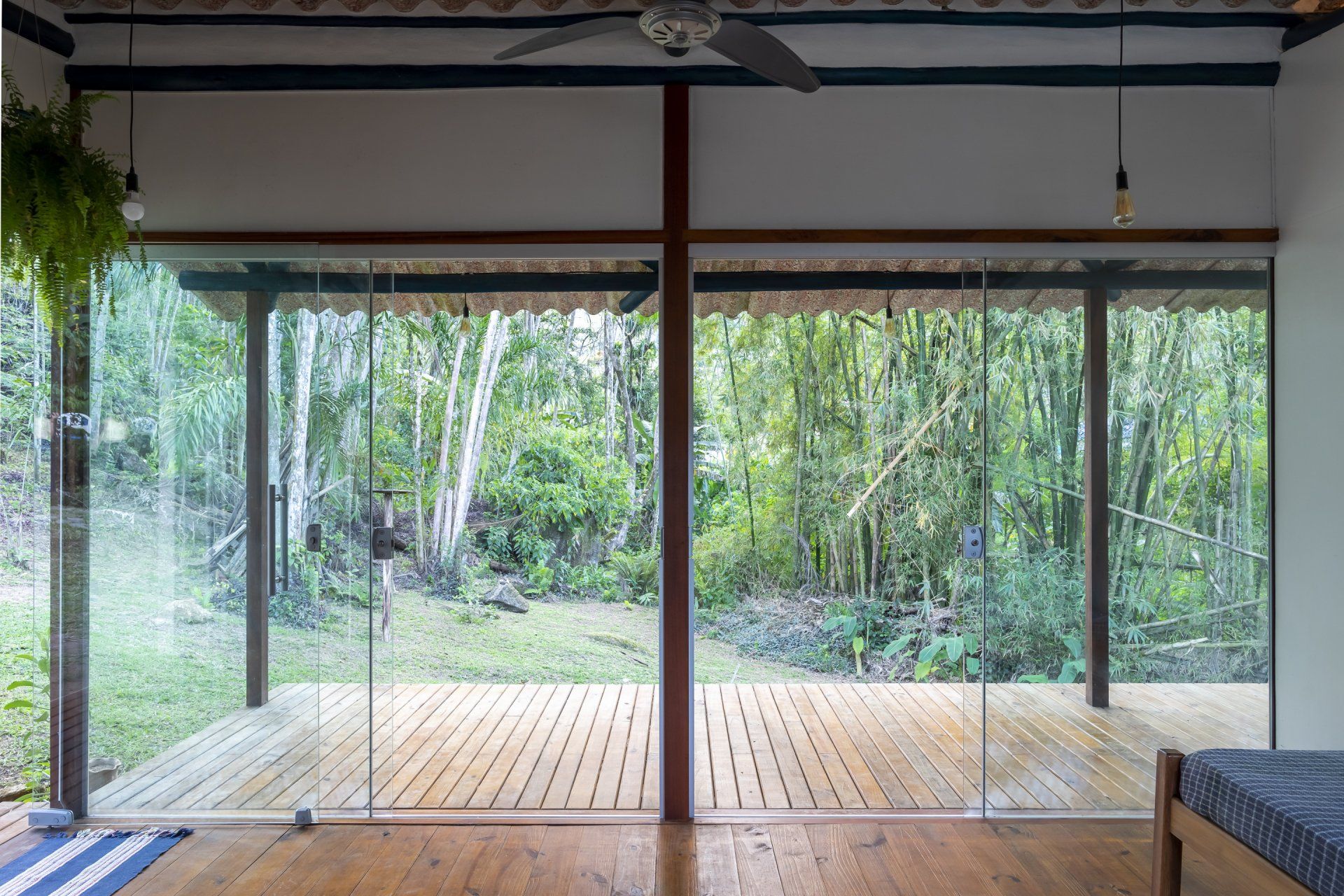 Uma sala com portas de correr de vidro que dão acesso a um deck de madeira.