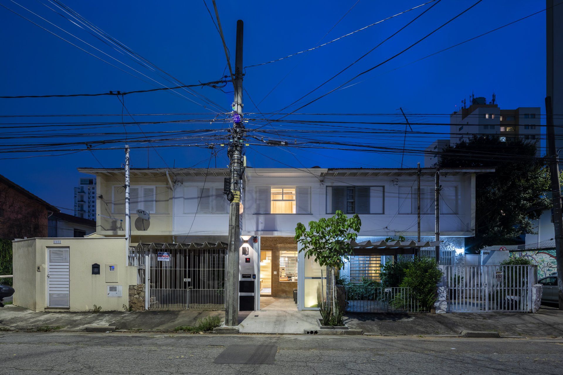 Uma fileira de casas está alinhada na beira de uma rua à noite.