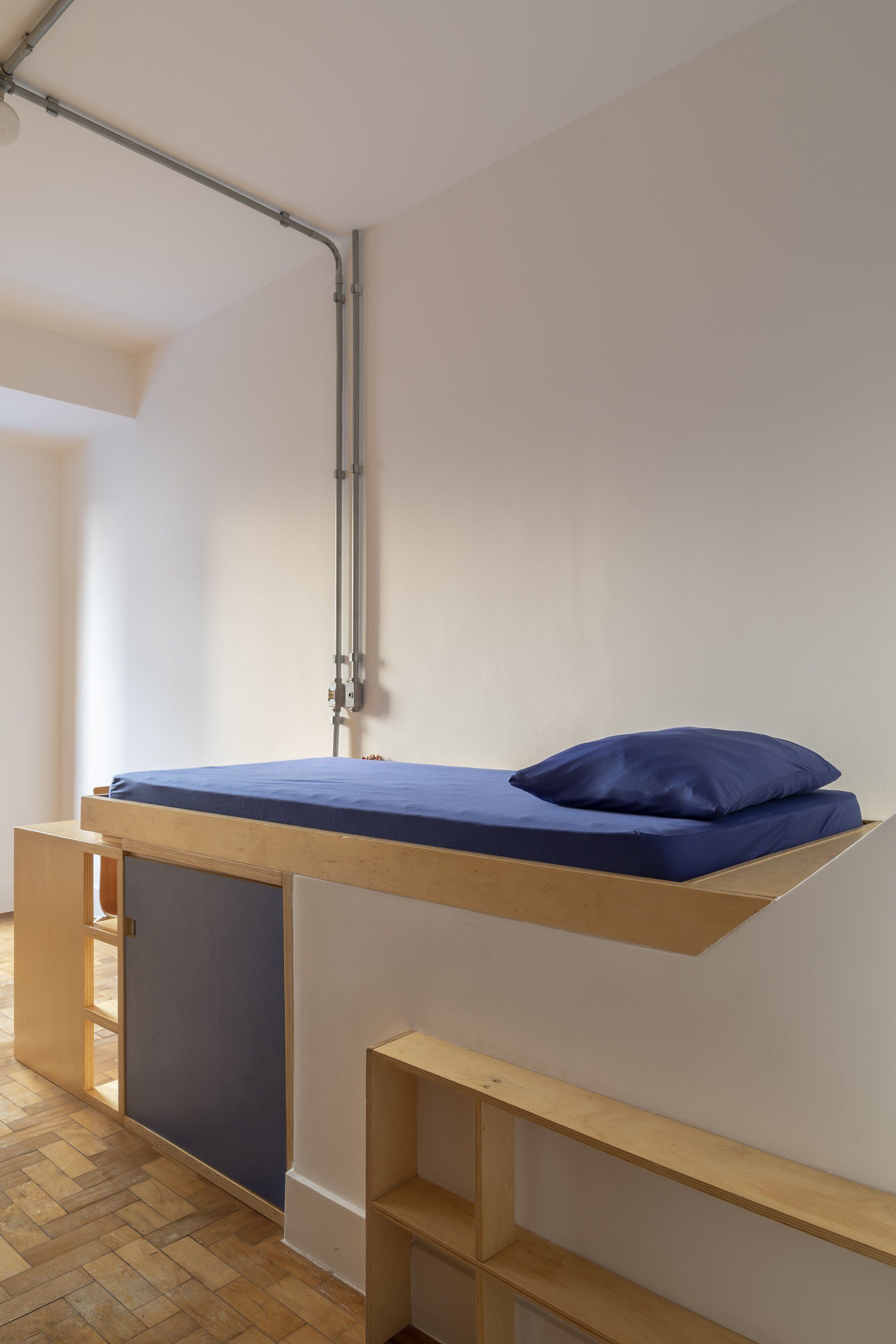Uma cama com colchão azul e travesseiro azul