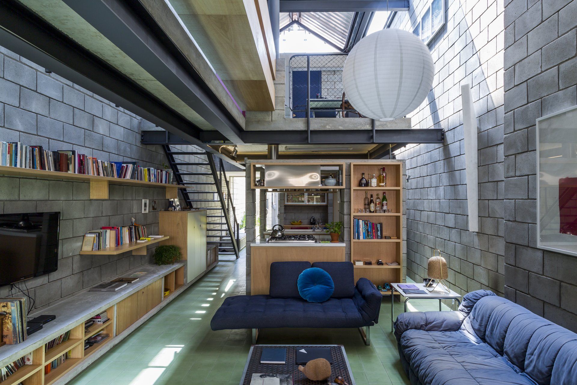 Uma sala com um sofá azul e uma televisão.