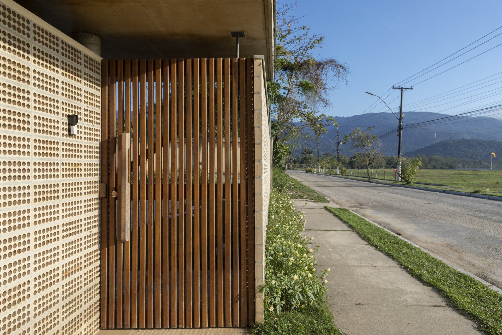 Uma porta de madeira está ao lado de uma calçada ao lado de uma estrada.
