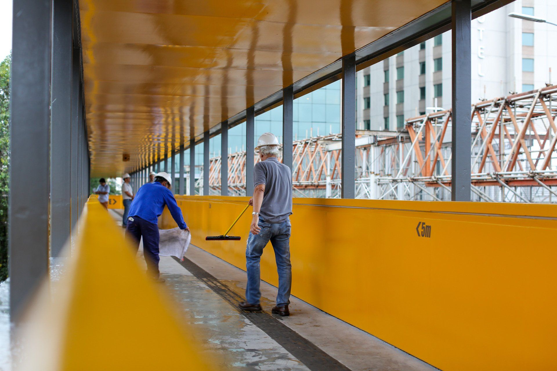 Um grupo de trabalhadores da construção civil está limpando uma ponte.