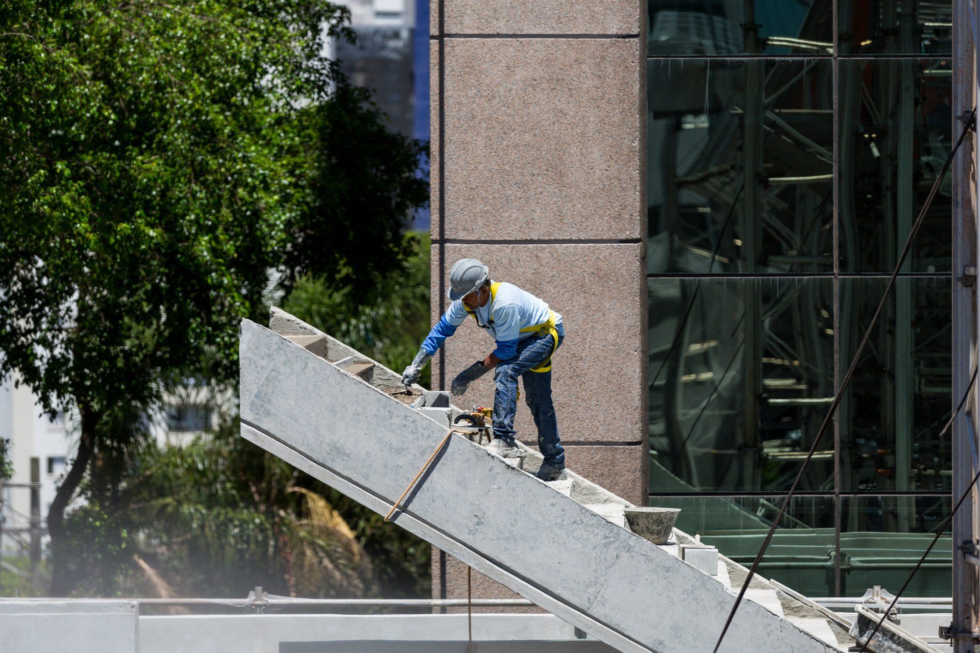 Um trabalhador da construção civil está trabalhando na lateral de um prédio.