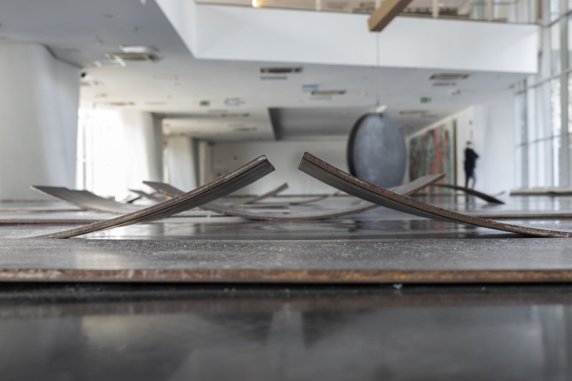 Uma escultura está no chão de um museu.