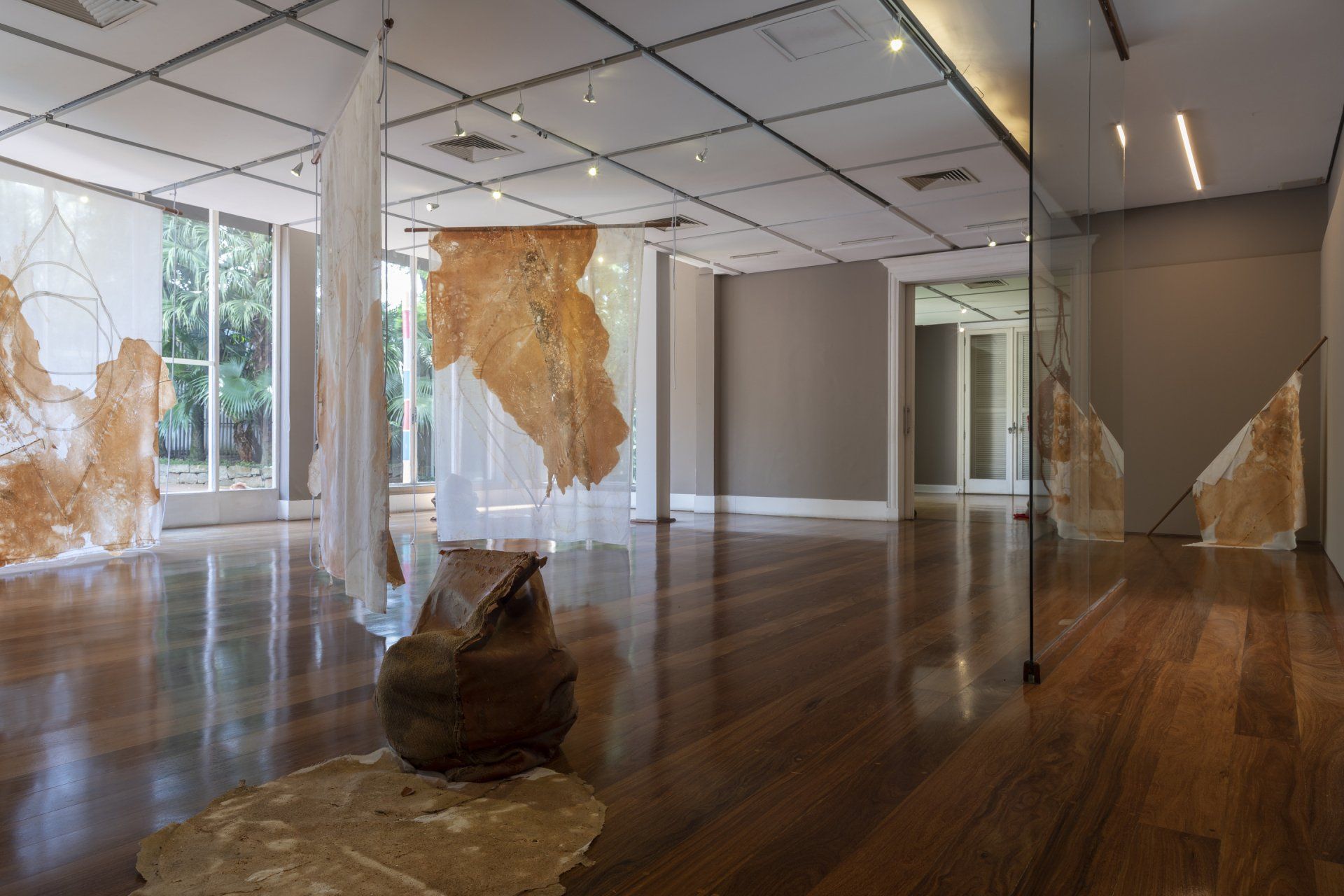 Uma grande sala vazia com piso de madeira e parede de vidro.