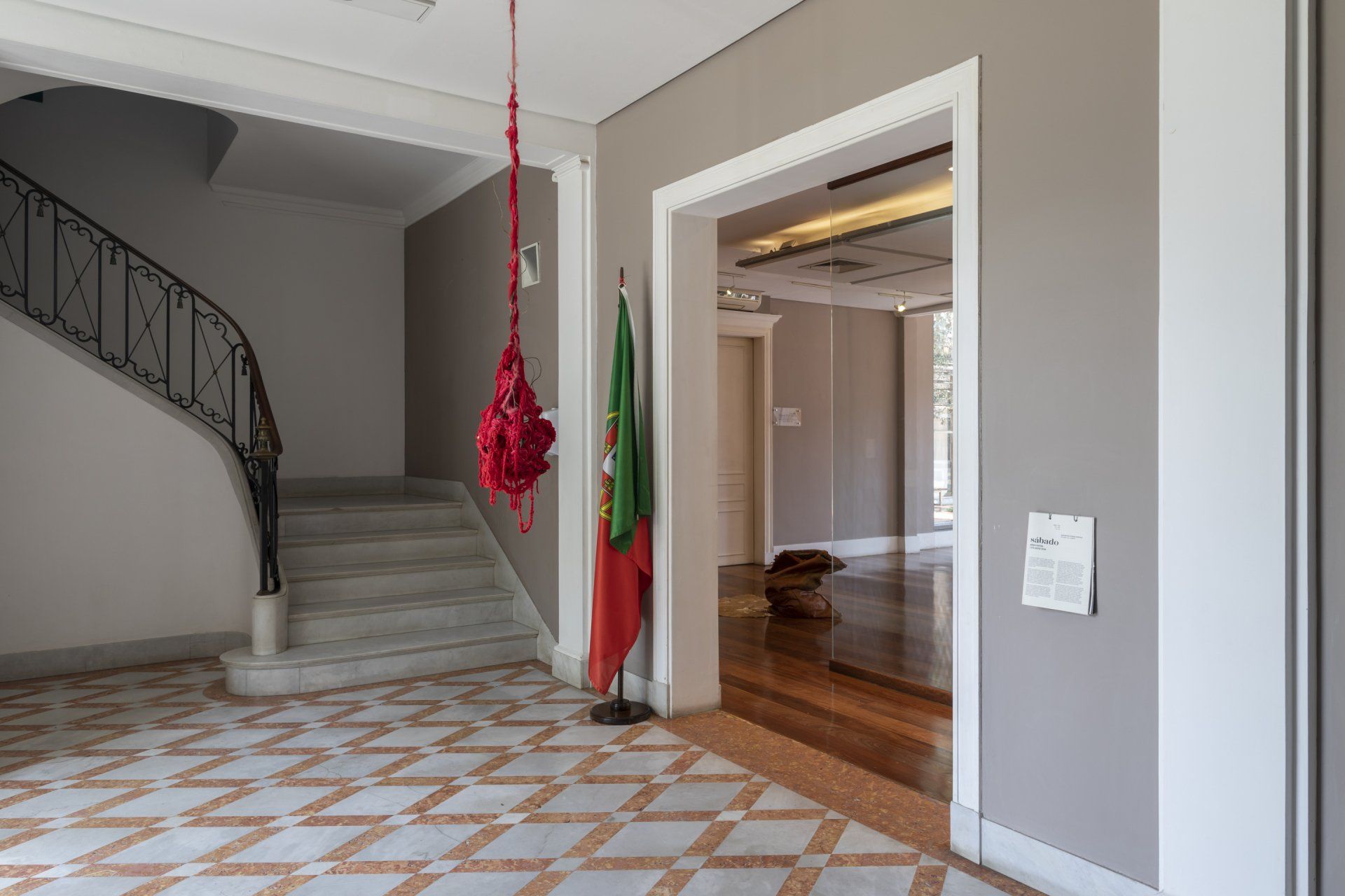 Um corredor com escadas e uma bandeira pendurada no teto.