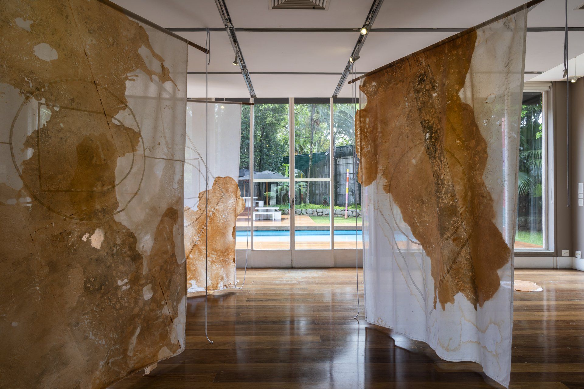 Uma sala com muitas pinturas na parede e uma piscina ao fundo.