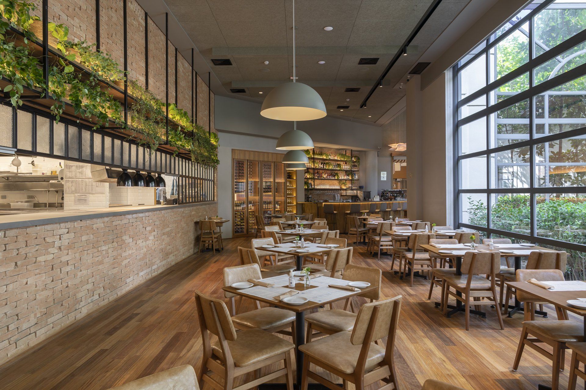 Um restaurante com mesas e cadeiras e uma grande janela.