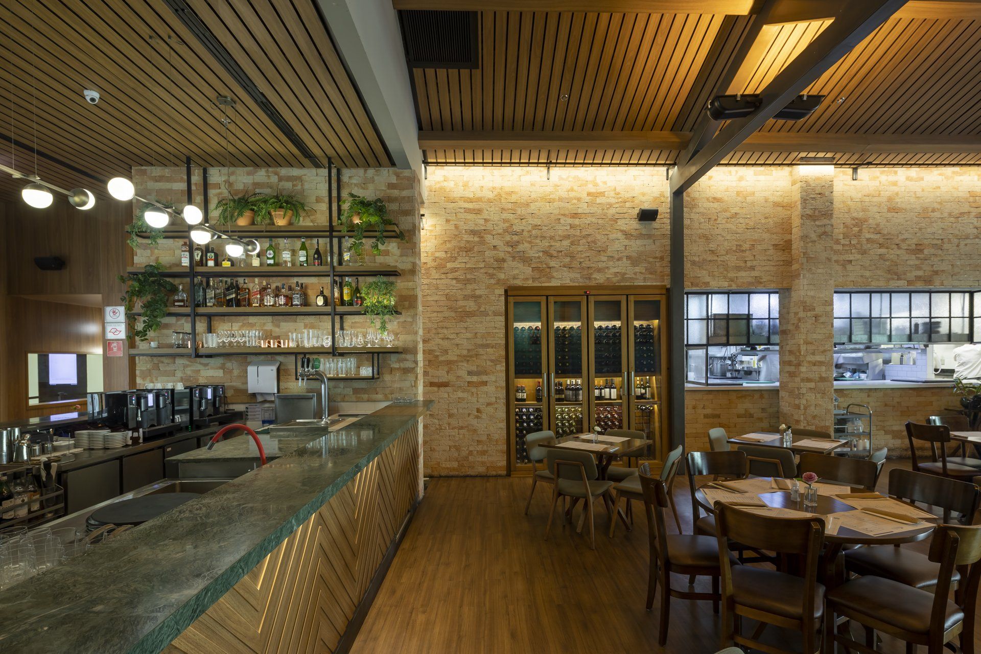 Um restaurante com mesas e cadeiras e um bar.