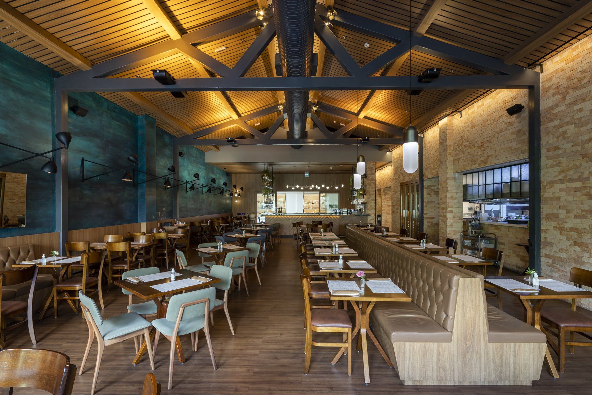 Um restaurante com mesas e cadeiras e uma parede de tijolos.