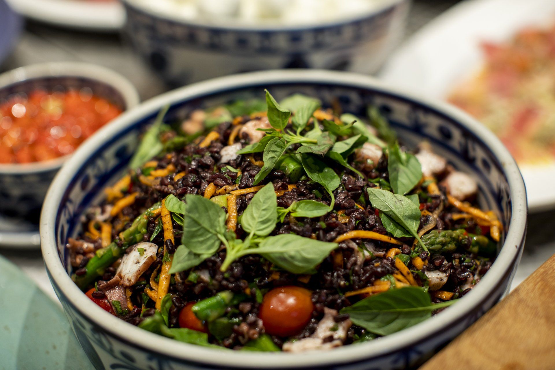 Uma tigela de comida com arroz e legumes sobre uma mesa.