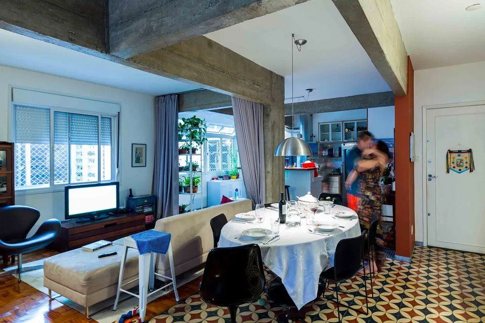 Uma sala de estar com mesa de jantar e sofá