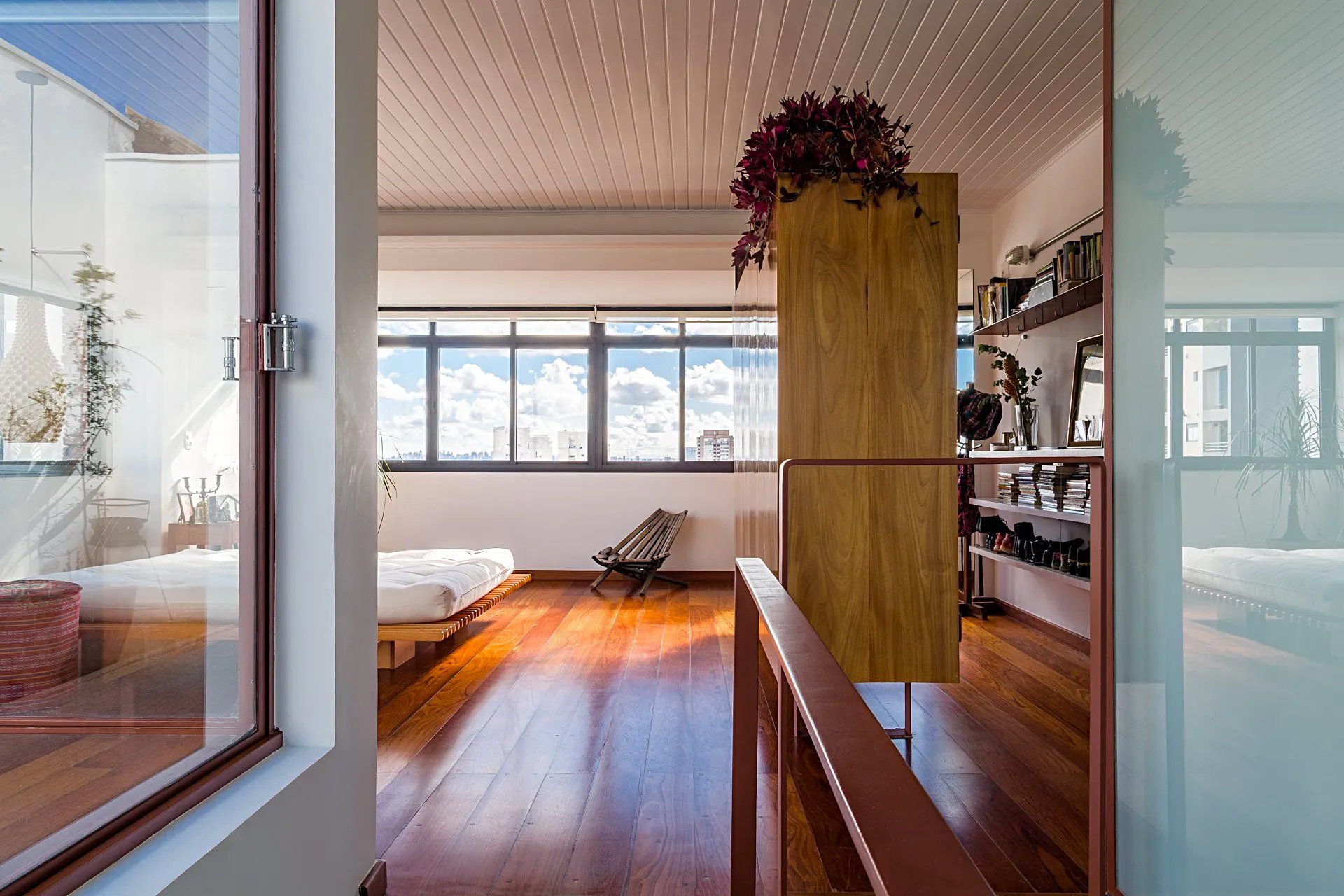 Uma sala com piso de madeira e uma grande janela