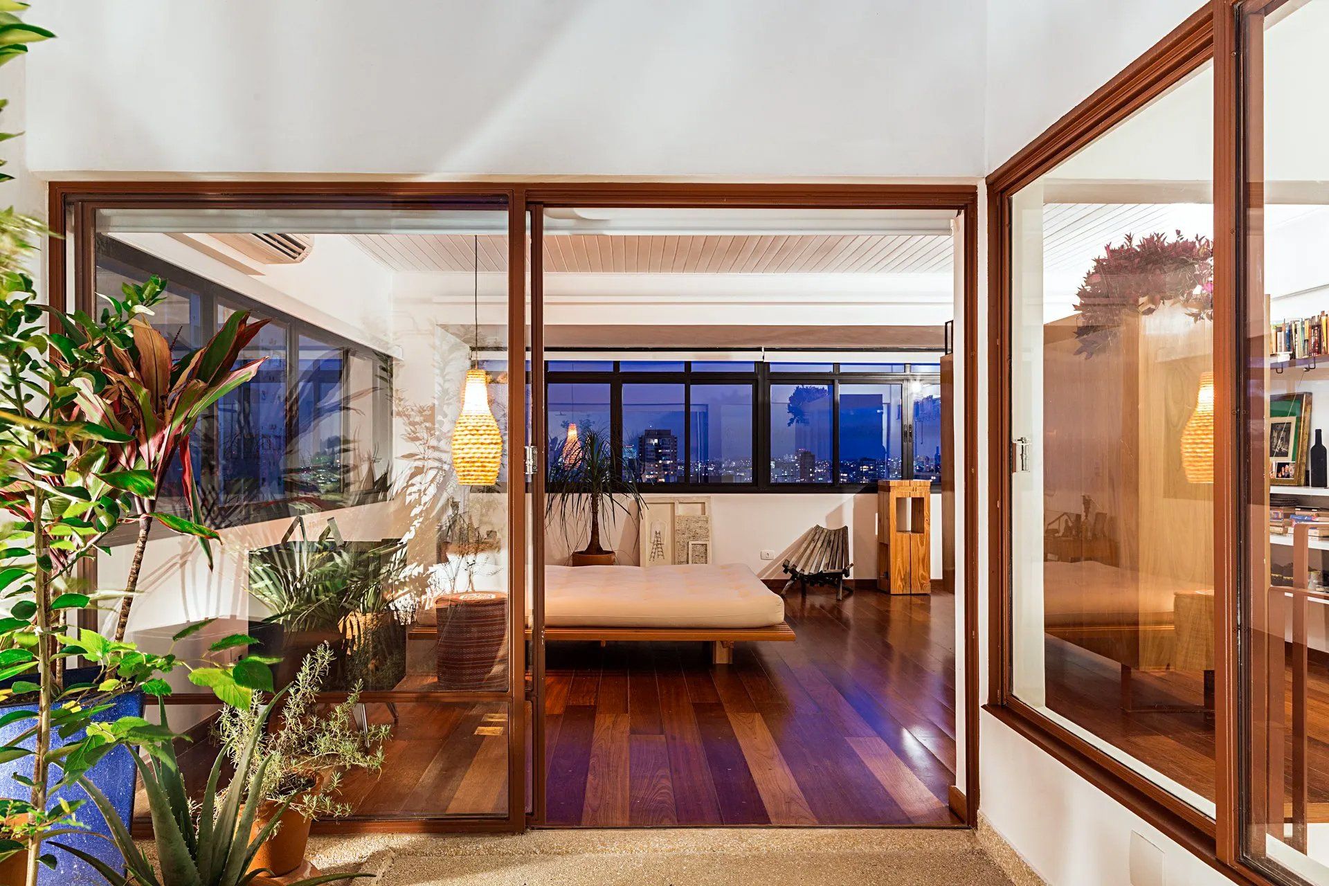 Sala de estar com piso de madeira e portas de correr de vidro