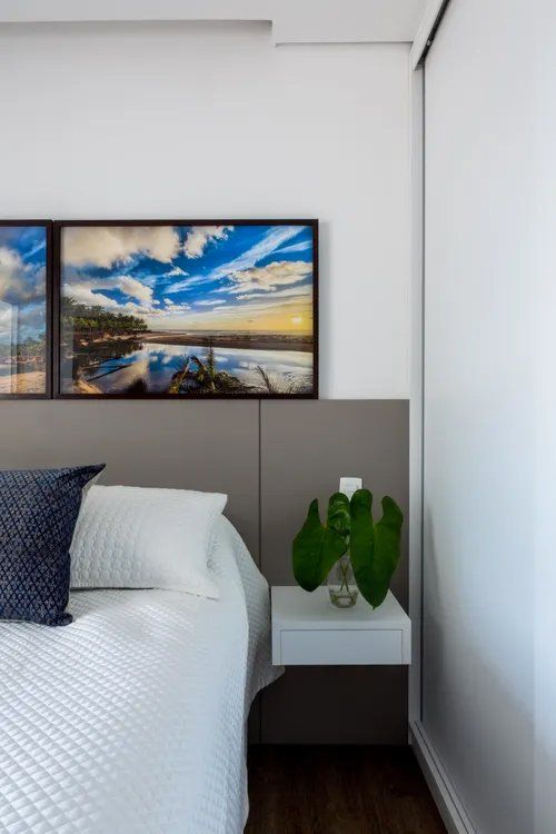 Um quarto com uma pintura na parede acima da cama