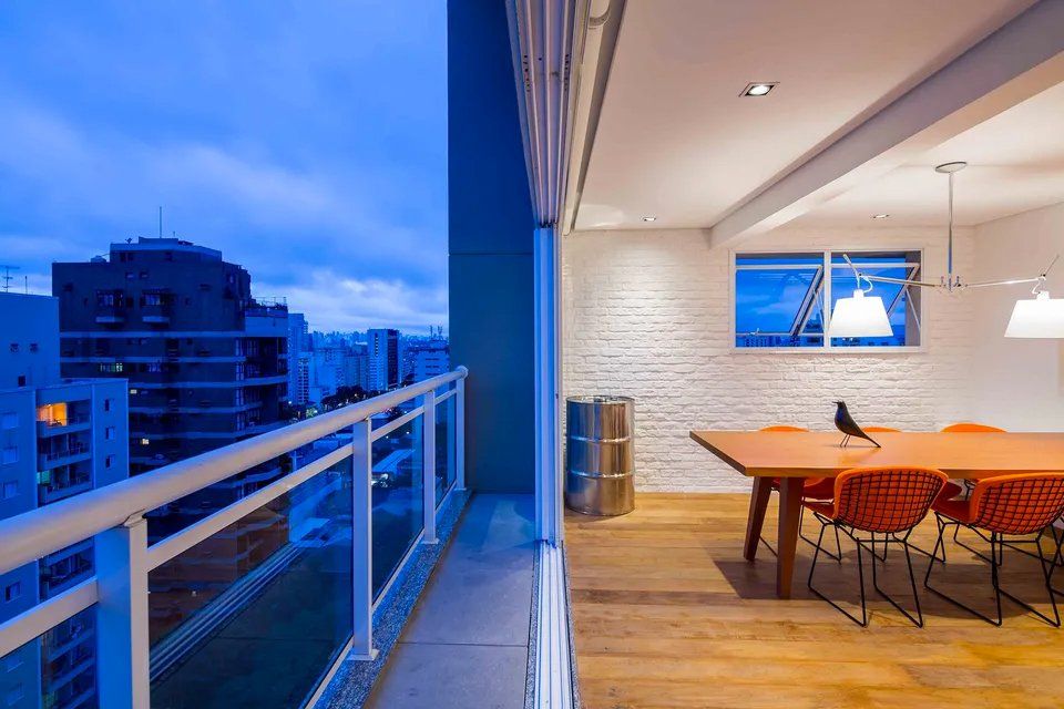 Uma varanda com vista para uma sala de jantar com mesa e cadeiras