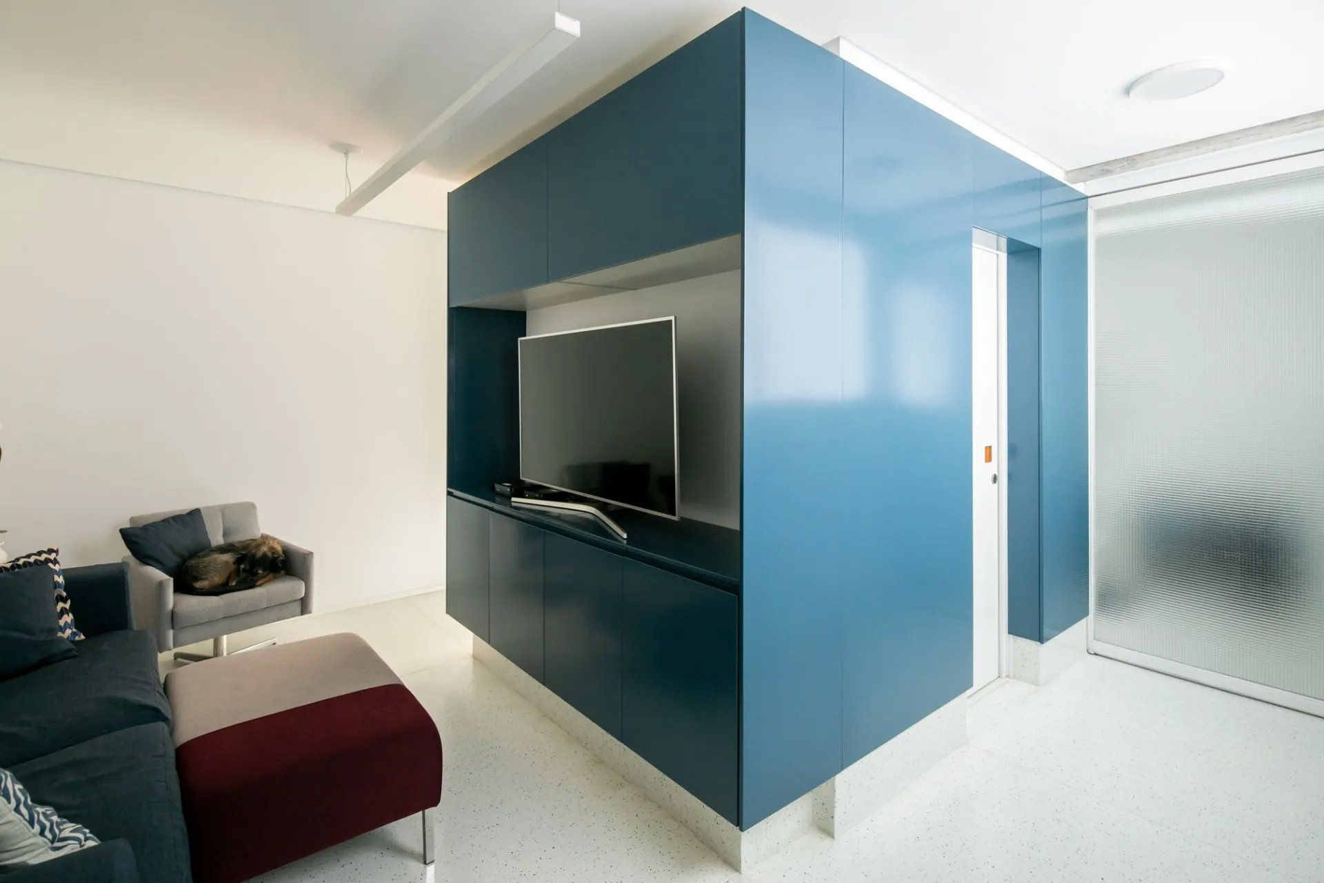 Uma sala de estar com parede azul e uma TV de tela plana