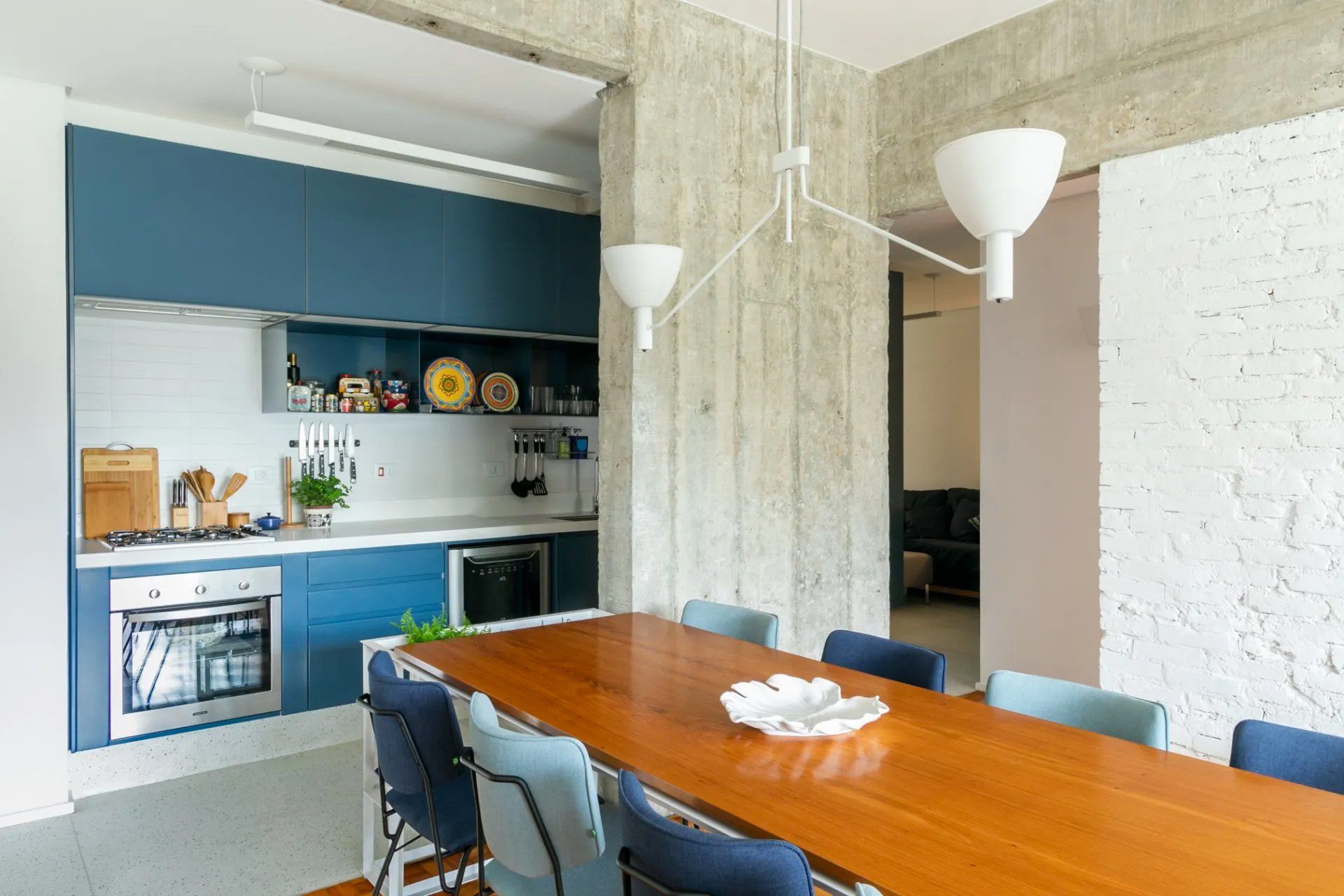 Uma cozinha e sala de jantar com uma longa mesa e cadeiras de madeira.