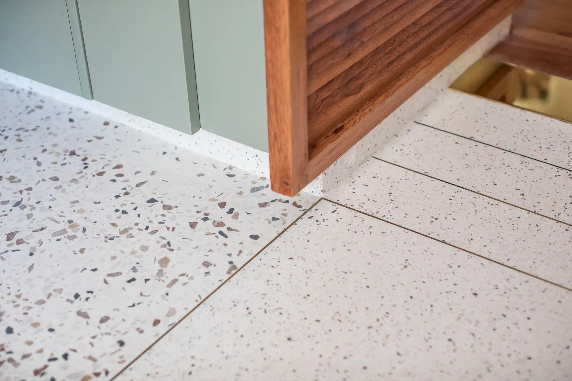 Um close de um piso de cerâmica branca com um canto de madeira.