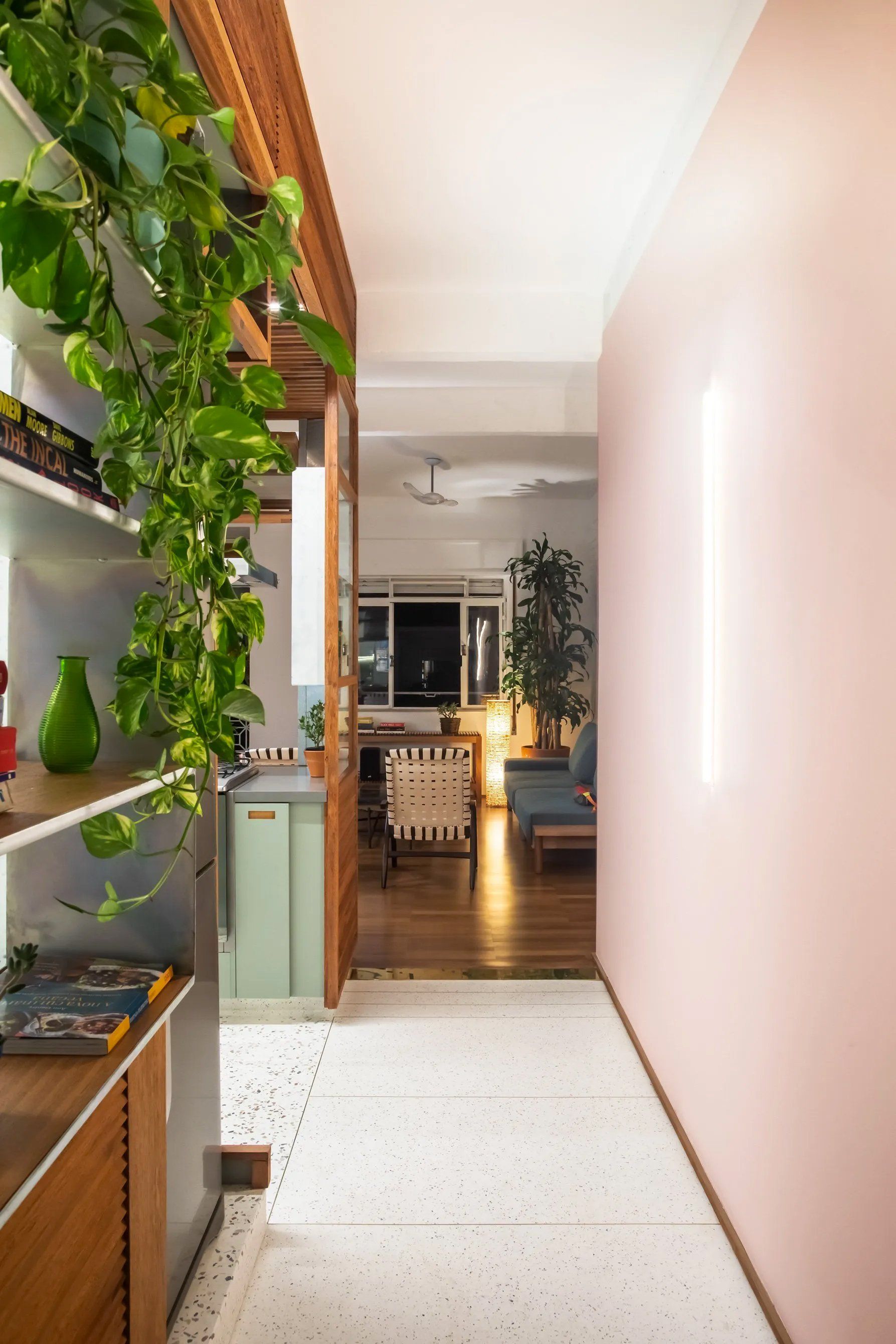 Um corredor que leva a uma sala com uma parede rosa.