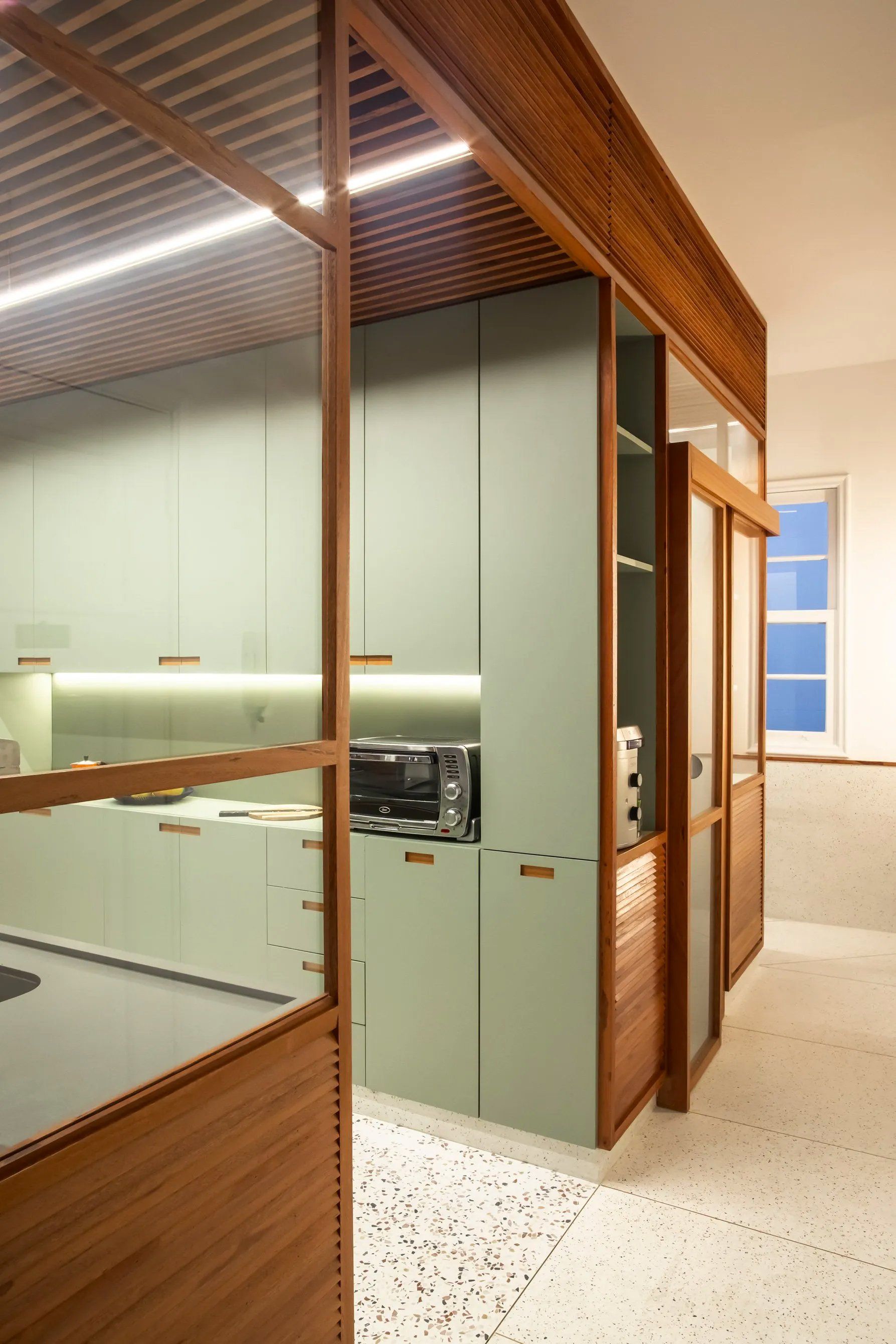 Uma cozinha com armários verdes e forno micro-ondas