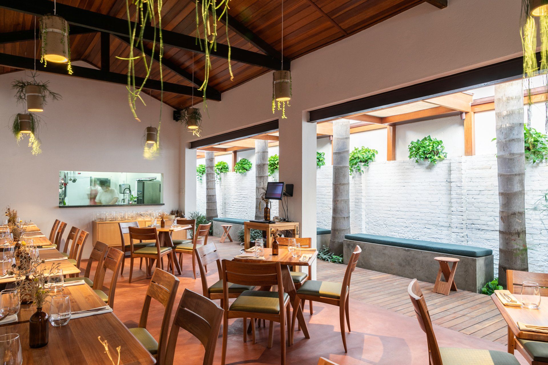 Um restaurante com mesas e cadeiras e teto de madeira