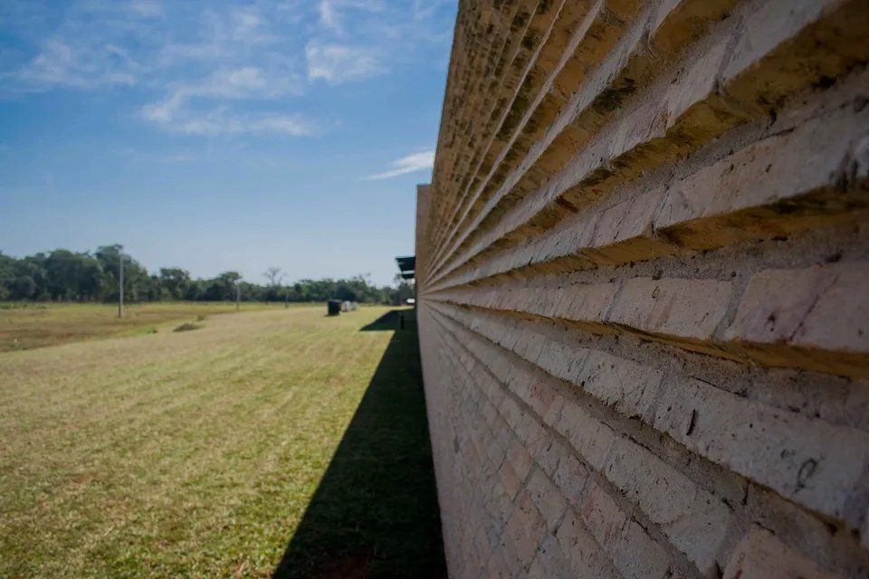 Uma parede de tijolos está no meio de um campo gramado.