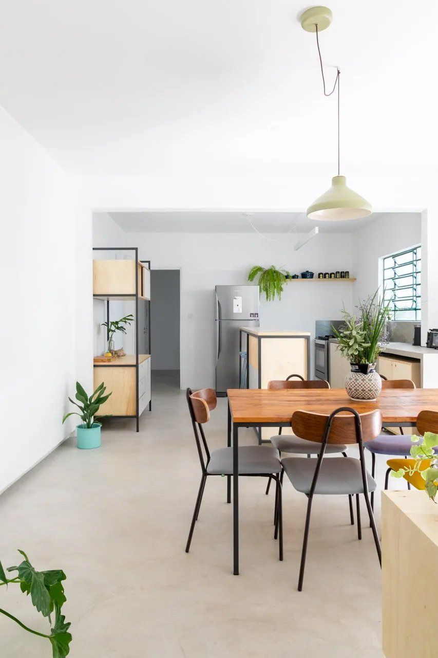Uma sala de jantar com mesa e cadeiras e uma geladeira