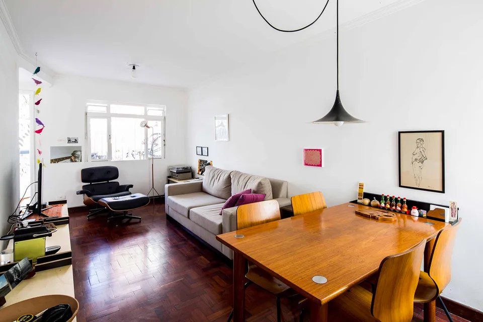Uma sala com sofá, mesa e cadeiras.
