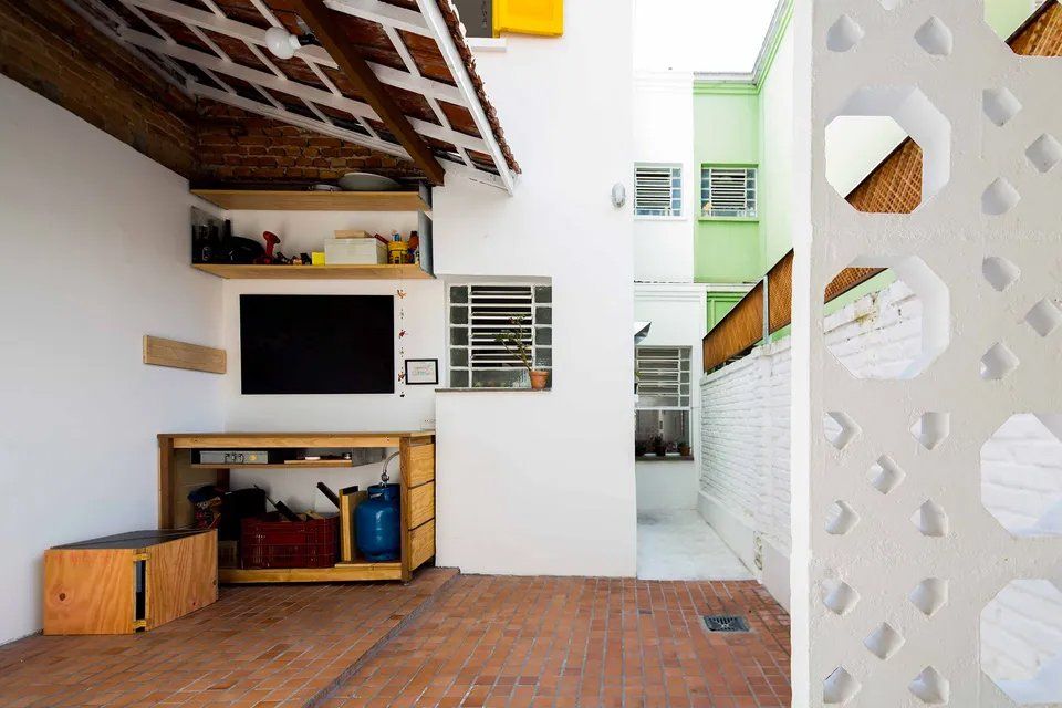 Um quarto com uma tv na parede e piso de tijolos