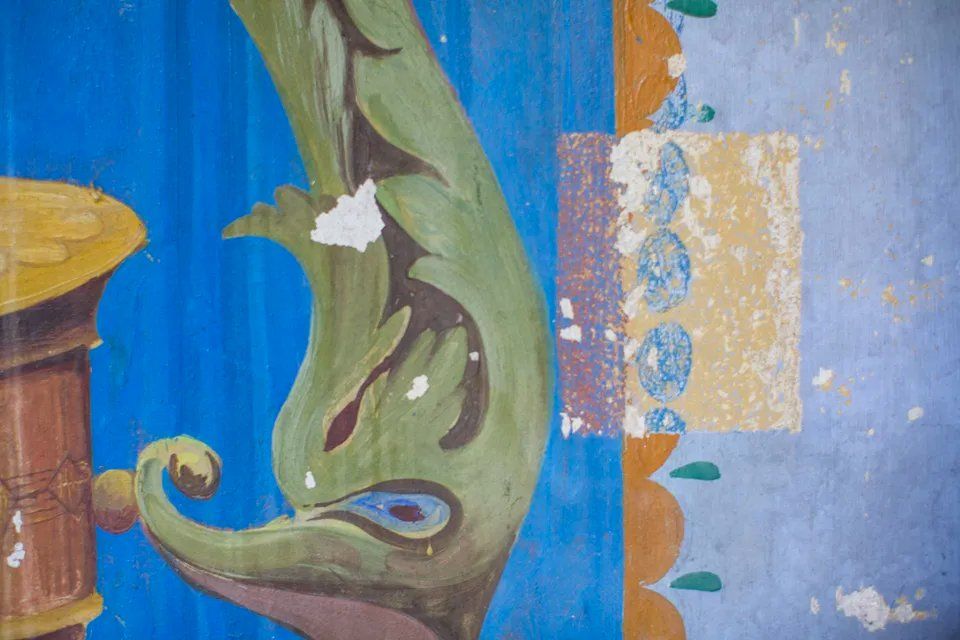 Um close de uma pintura de um dragão em uma parede azul.
