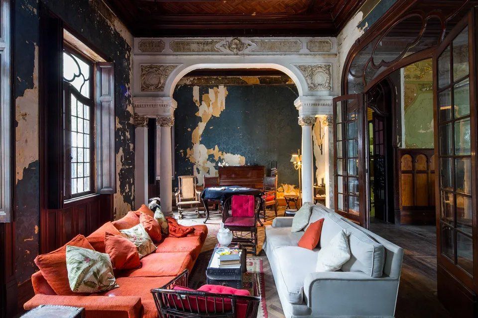 Uma sala repleta de móveis e um piano.