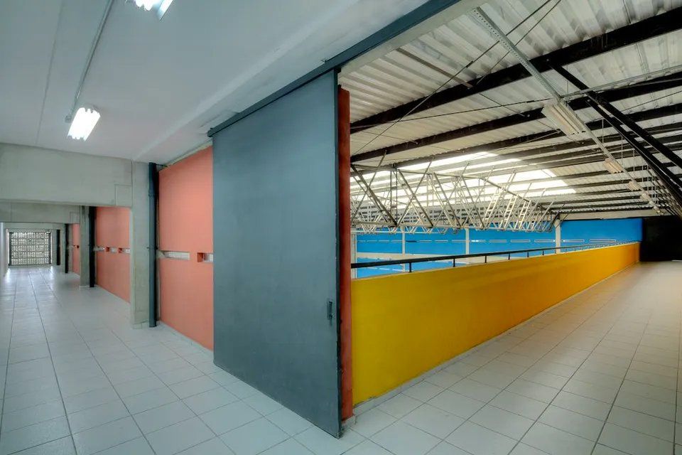 Um corredor vazio com uma porta deslizante entre duas paredes
