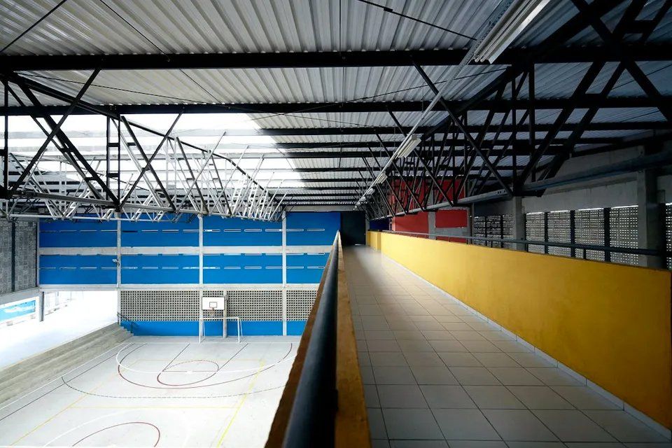Um longo corredor que leva a uma quadra de basquete em um prédio