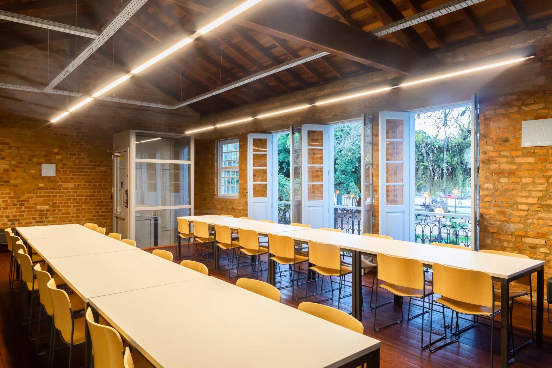 Há muitas mesas e cadeiras nesta sala.