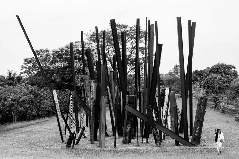Uma foto em preto e branco de uma escultura em um parque